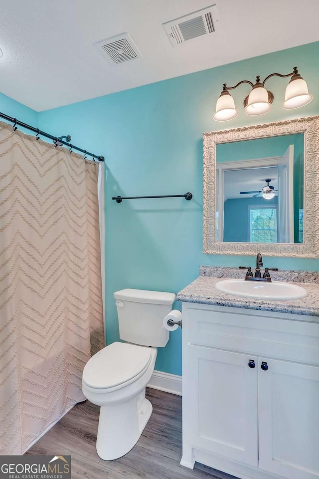 bathroom featuring vanity, hardwood / wood-style flooring, a shower with curtain, and toilet