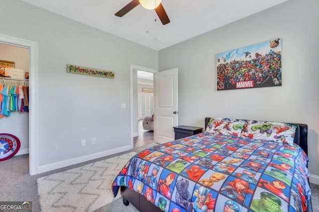 carpeted bedroom with ceiling fan, a spacious closet, and a closet