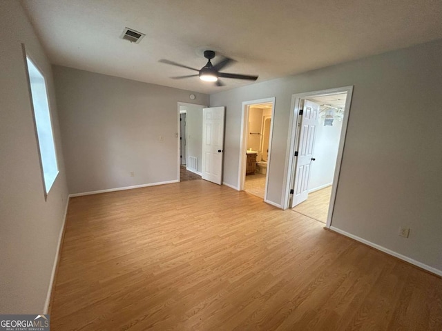 unfurnished bedroom featuring ensuite bathroom, ceiling fan, and light wood-type flooring