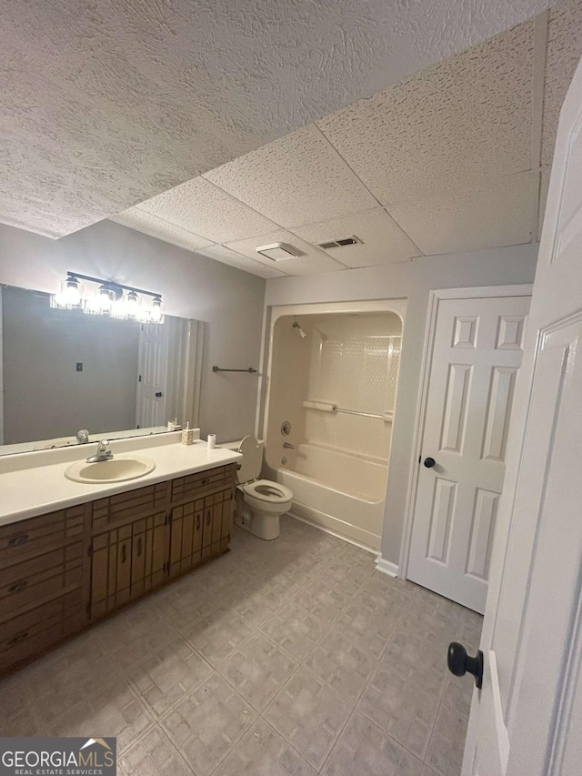 full bathroom with shower / bathtub combination, vanity, toilet, and a paneled ceiling