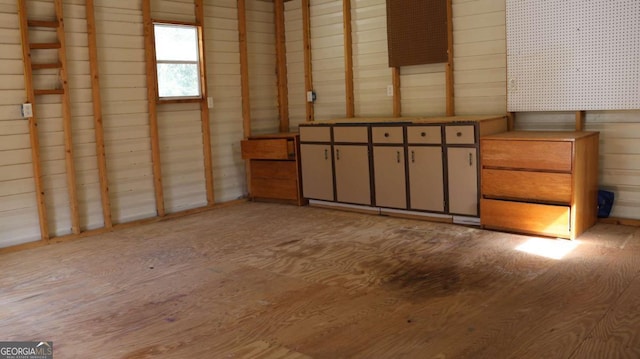 interior space with light hardwood / wood-style floors and wood walls