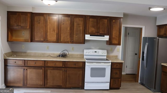 kitchen featuring white electric range, stainless steel fridge with ice dispenser, and light wood-type flooring