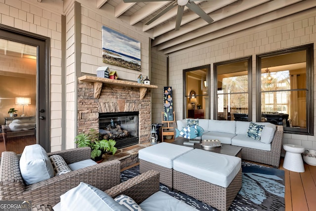 living room with beamed ceiling, ceiling fan, wood-type flooring, and an outdoor stone fireplace