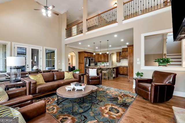 living room with crown molding, ceiling fan, and light hardwood / wood-style floors