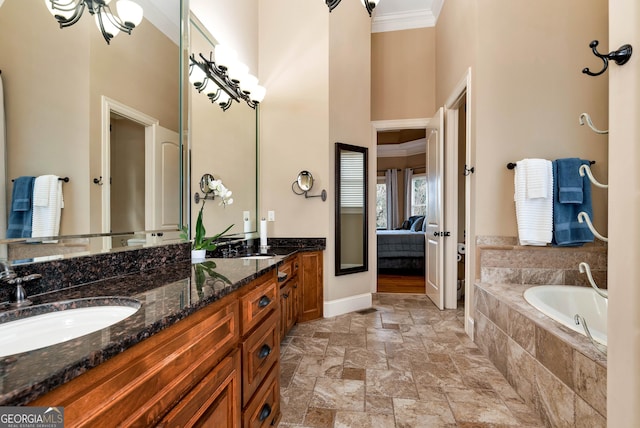 bathroom with vanity, tiled tub, crown molding, and a towering ceiling