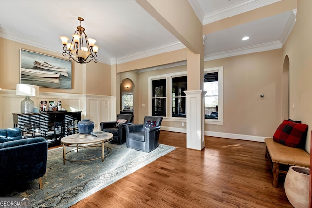 living room with crown molding, hardwood / wood-style flooring, and a chandelier