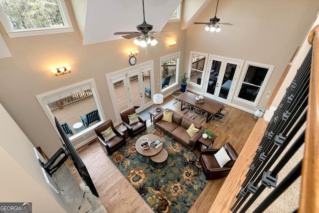 living room with french doors, ceiling fan, high vaulted ceiling, and hardwood / wood-style flooring