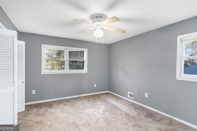 unfurnished bedroom with light carpet, a closet, and ceiling fan