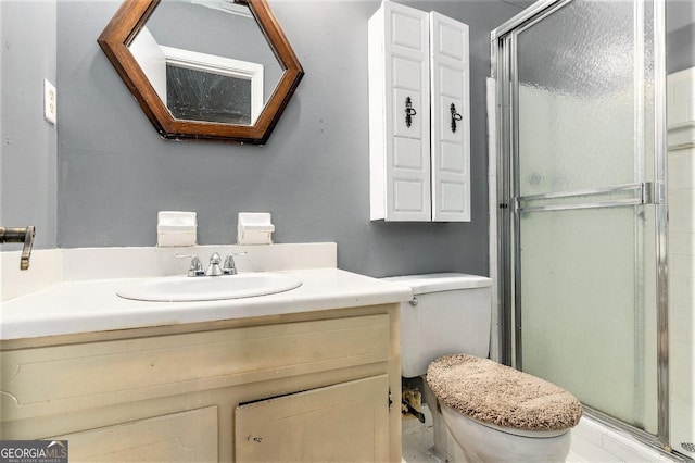 bathroom featuring vanity, an enclosed shower, and toilet