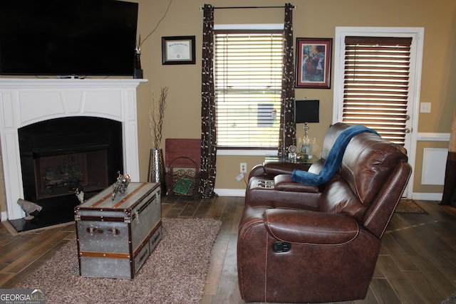 living area with dark wood-style floors, a fireplace, and baseboards