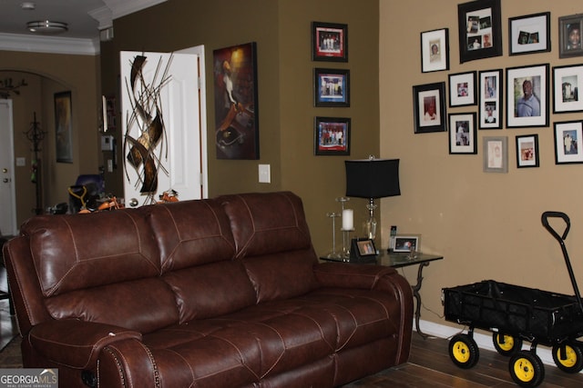 living area featuring arched walkways, crown molding, baseboards, and wood finished floors