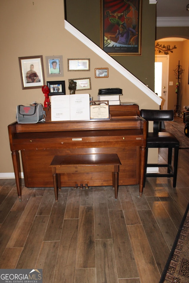 room details with ornamental molding, wood tiled floor, arched walkways, and baseboards