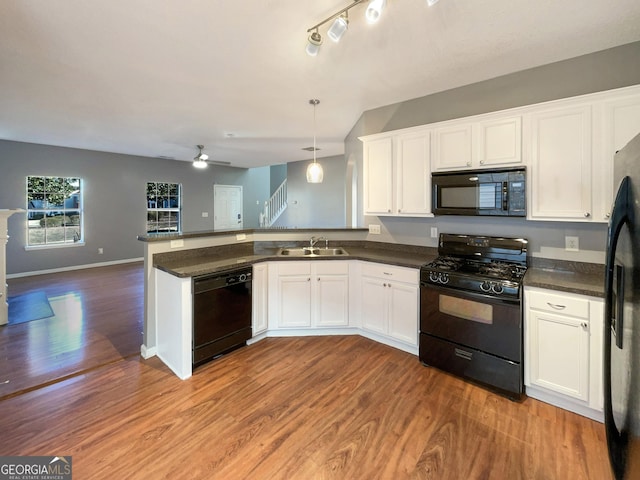 kitchen featuring decorative light fixtures, sink, white cabinets, and black appliances