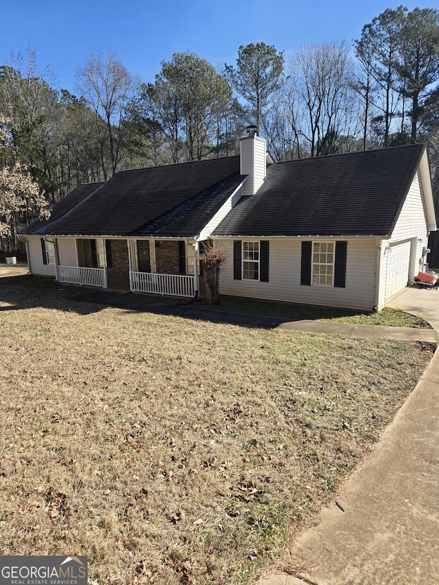 view of front of house with covered porch, a chimney, and a front yard