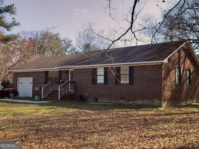 ranch-style home with a garage, brick siding, and a front lawn