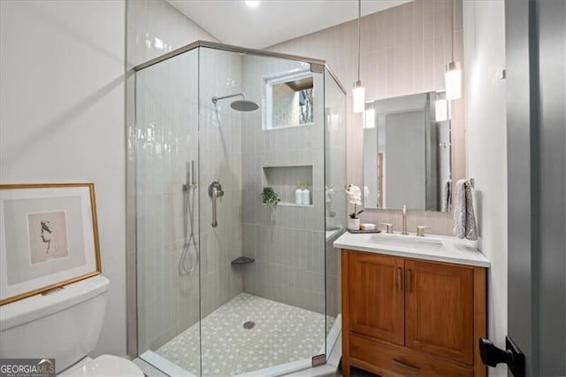 full bath with tasteful backsplash, a stall shower, vanity, and toilet