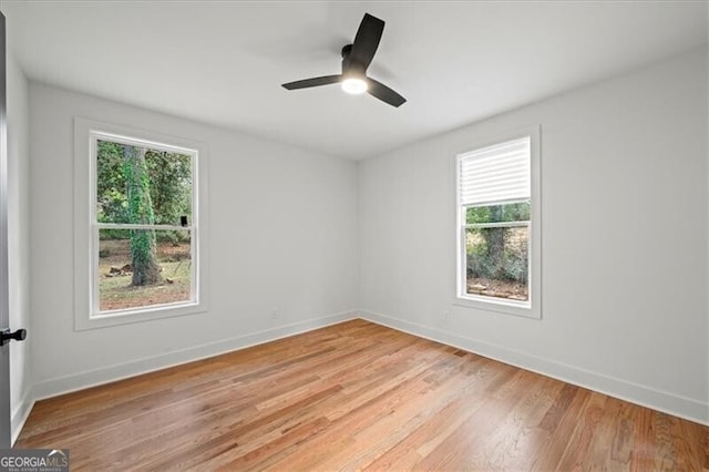 empty room featuring baseboards, ceiling fan, and light wood-style floors