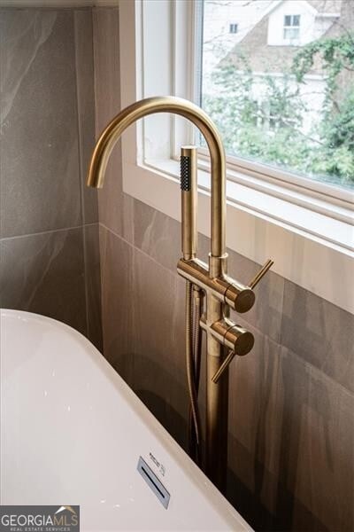 interior details with tiled shower and a sink