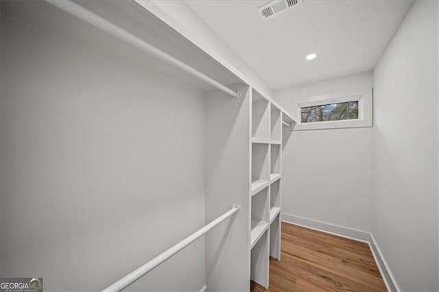 spacious closet featuring visible vents and wood finished floors