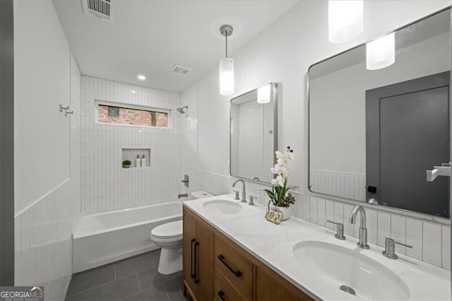 bathroom featuring toilet, a sink, visible vents, and tile patterned floors