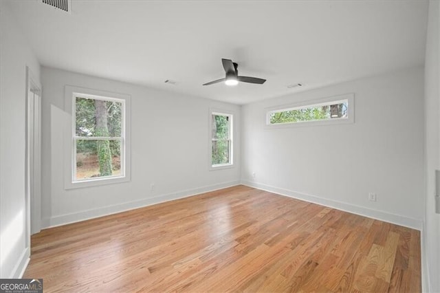 unfurnished room featuring light wood finished floors, visible vents, and baseboards