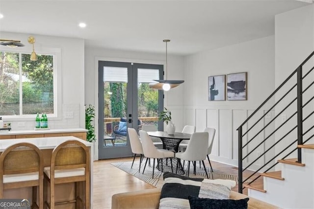 dining room featuring a healthy amount of sunlight, stairway, and french doors