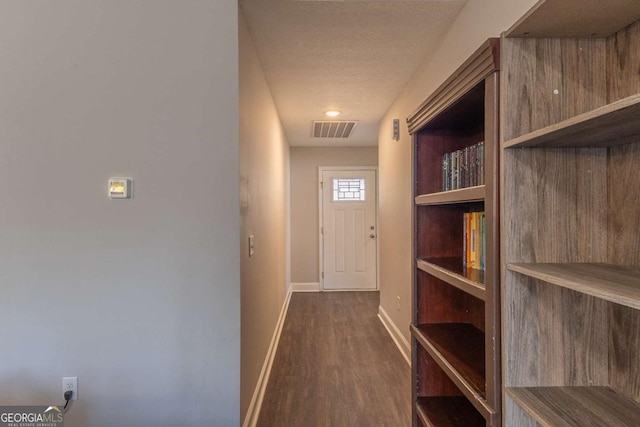 interior space with dark wood-type flooring and a textured ceiling