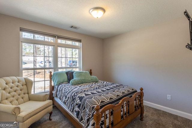 carpeted bedroom featuring multiple windows and a textured ceiling