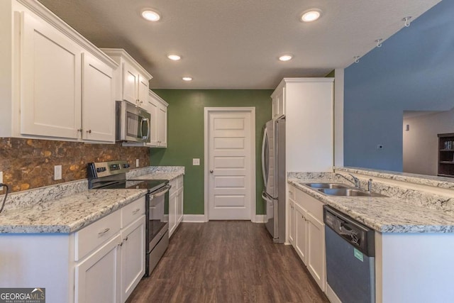 kitchen with sink, white cabinets, dark hardwood / wood-style flooring, decorative backsplash, and stainless steel appliances