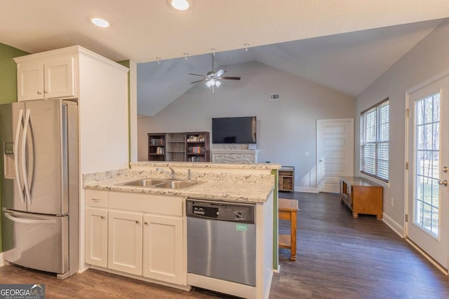 kitchen featuring appliances with stainless steel finishes, white cabinetry, sink, kitchen peninsula, and light stone countertops