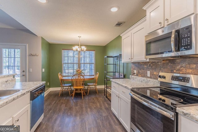 kitchen with white cabinetry, hanging light fixtures, stainless steel appliances, tasteful backsplash, and dark hardwood / wood-style flooring