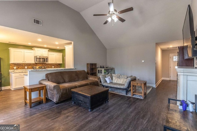 living room featuring dark hardwood / wood-style flooring, high vaulted ceiling, and ceiling fan