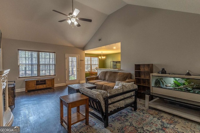 living room featuring ceiling fan with notable chandelier, dark wood-type flooring, and high vaulted ceiling