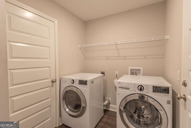 laundry room with washing machine and clothes dryer and dark hardwood / wood-style floors