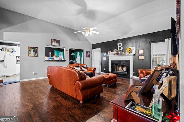 living room featuring dark wood-type flooring, ceiling fan, and vaulted ceiling