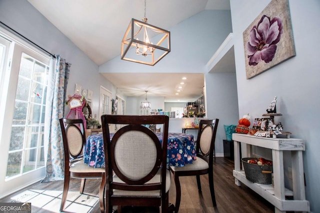 dining space featuring vaulted ceiling, plenty of natural light, hardwood / wood-style floors, and a notable chandelier