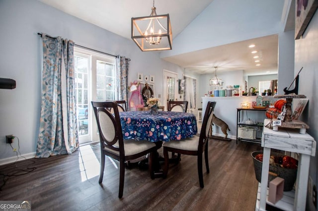 dining room featuring dark hardwood / wood-style floors, a chandelier, and vaulted ceiling