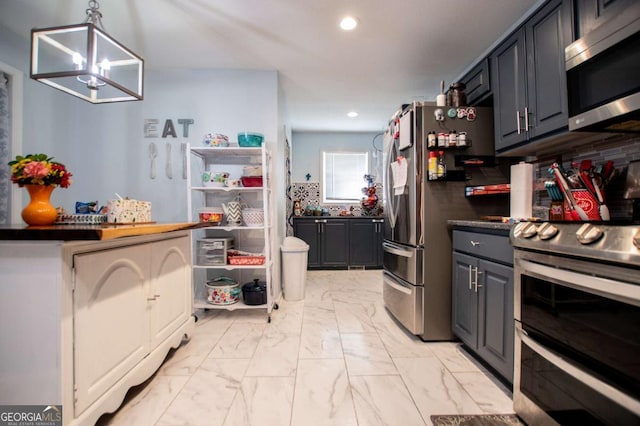 kitchen featuring gray cabinetry, decorative light fixtures, a notable chandelier, stainless steel appliances, and backsplash