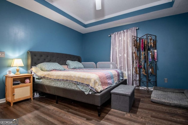 bedroom featuring a raised ceiling, ornamental molding, and hardwood / wood-style floors