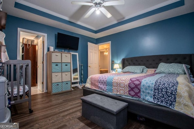 bedroom featuring hardwood / wood-style floors, a tray ceiling, ornamental molding, and ceiling fan