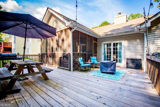 wooden deck with a sunroom and grilling area