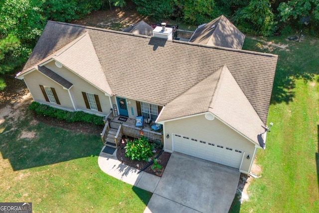 view of front of house featuring a garage, a front yard, and covered porch