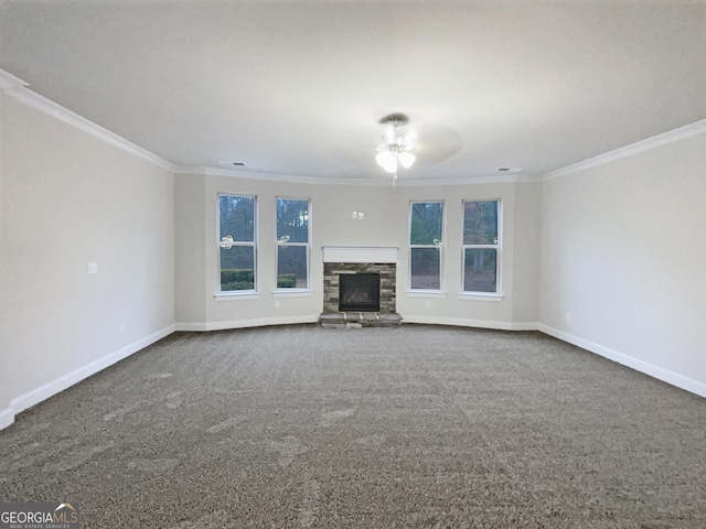 unfurnished living room featuring crown molding, a stone fireplace, carpet flooring, and plenty of natural light