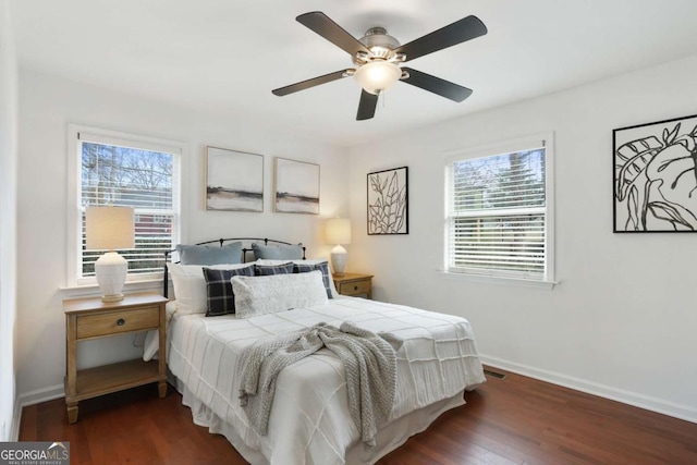 bedroom with multiple windows, dark hardwood / wood-style flooring, and ceiling fan