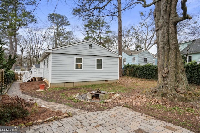 view of side of home featuring a patio area and a fire pit