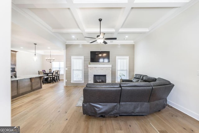 living area with light wood-style floors, coffered ceiling, beamed ceiling, and baseboards