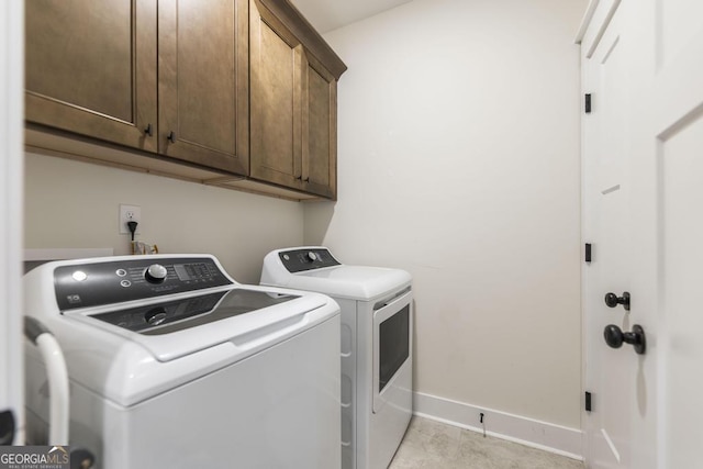 laundry area featuring cabinet space, baseboards, and washer and dryer