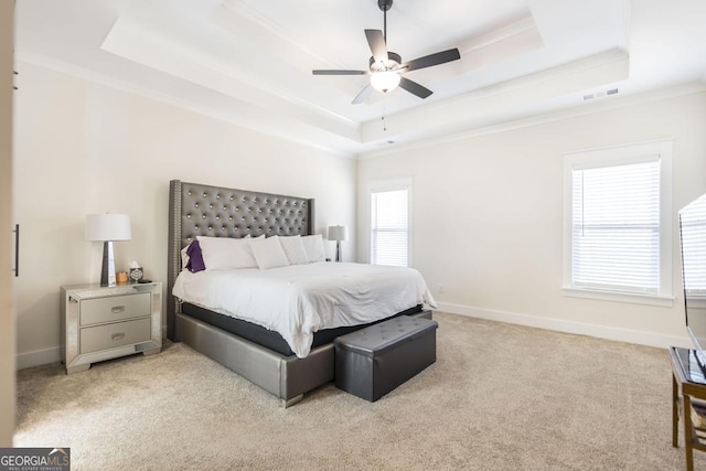 bedroom featuring light carpet, visible vents, baseboards, a raised ceiling, and crown molding