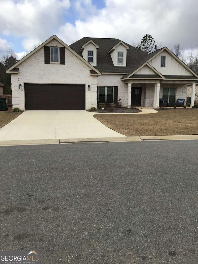 view of front facade with driveway, brick siding, a garage, and roof with shingles