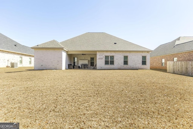 back of house featuring central AC, brick siding, a ceiling fan, roof with shingles, and a patio area